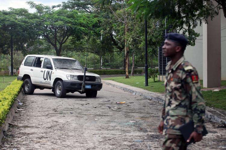 TERRORANGREB. Nigeriansk soldat ved beskadiget FN-bil ud for den bomberamte bygning i Abuja. 