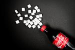 Sukker. Den halve liter Coca-Cola Regular indeholder 54 gram sukker. 
