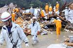 Brandmænd og redningsfolk gennemsøger nedstyrtede huse i Wakayama-området. Kraftig regn har ført til mudderskred. 