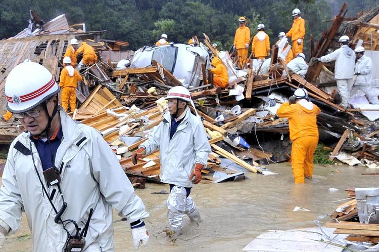 Brandmænd og redningsfolk gennemsøger nedstyrtede huse i Wakayama-området. Kraftig regn har ført til mudderskred. 