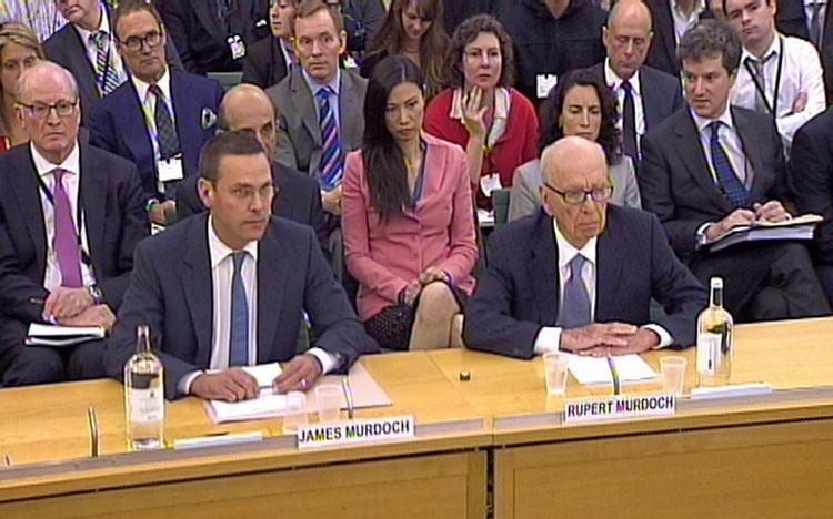 For en måned siden sad Rupert Murdoch og hans søn James Murdoch til afhøring blandt parlamentsmedlemmerne. Bag ved de to sidder Rupert Murdochs kone, Wendi. 