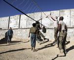 MILITÆRBASE. Ringmuren omkring Sayed Abad-basen hindrede, at bilbombe medførte langt større ødelæggelser på basen. Her ses den på en foto, hvor afghanske og amerikanske soldater spiller volley. 
