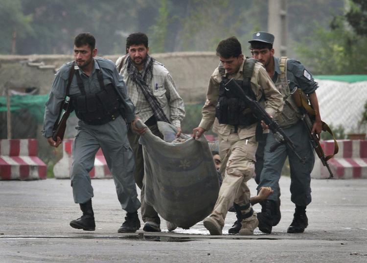 Angreb. Afghanske sikkerhedsstyrker bærer på liget af en kollega, som blev dræbt under Talebans angreb på ambassadekvarteret i Kabul i går. 