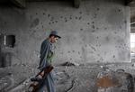 KAMPPLADS. Afghansk politibetjent i den bygning, angrebene skete fra. Skudhuller i væggen taler om forsøgene på at få ram på terroristerne i ejendommen. 