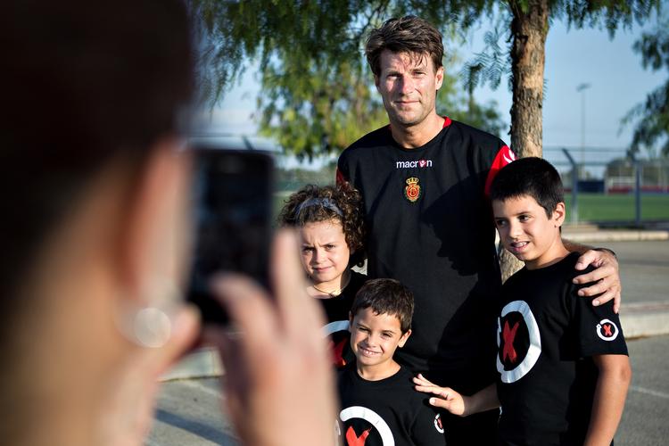 vellidt. Et par unge Mallorcafans bliver fotograferet med træneren, der er i modvind for tiden. 