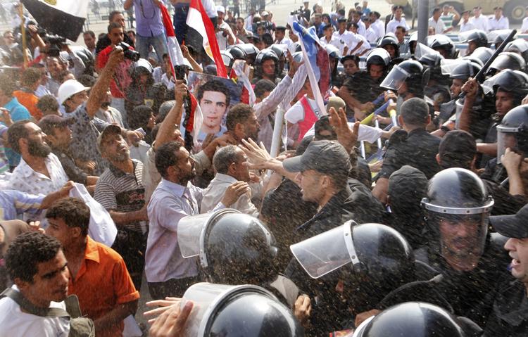 Uro. Uden for retssalen i Kairo kastede de forsamlede sten mod politiet, mens Mubarak var for retten. 