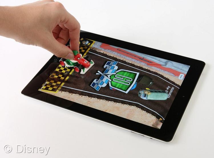 I bunden af hver legetøjsbil fra filmen 'Biler 2' er en sensor, som app´en på iPad´en kan aflæse, og dermed reagerer alt efter, hvordan børnene futter rundt med bilen oven på skærmen. 