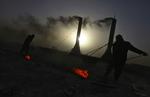 2010: Arbejdsmænd skovler kul i udkanten af Kabul. Gennemsnitslønnen ligger på mellem 200 og 300 dollars for disse mænd. 