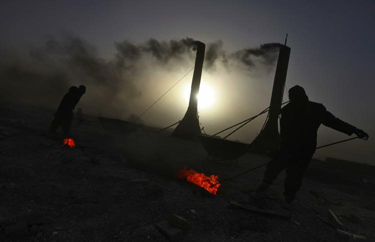 2010: Arbejdsmænd skovler kul i udkanten af Kabul. Gennemsnitslønnen ligger på mellem 200 og 300 dollars for disse mænd. 