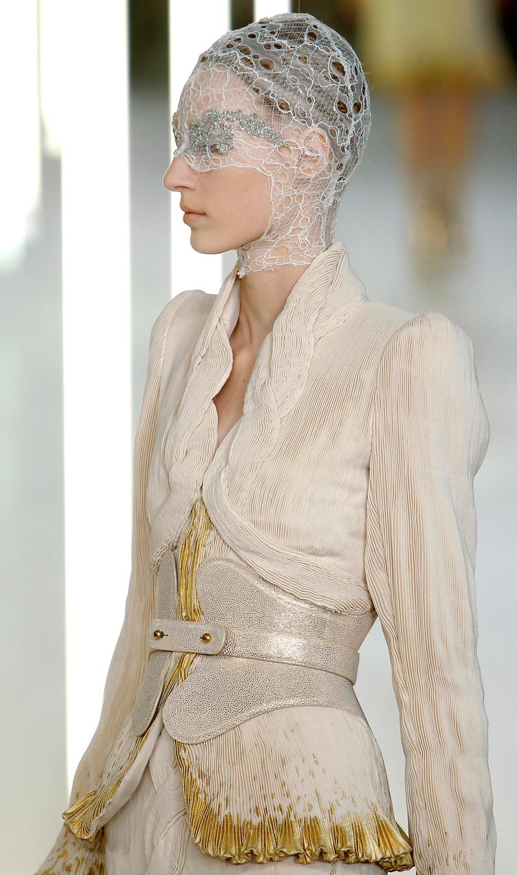 mode som teater. Modeller  på rad og række ved Sarah Burtons præsentation af forårskollektionen hos Alexander McQueen. The Guardian kalder hende en værdig arvtager for den afdøde modeskaber. 