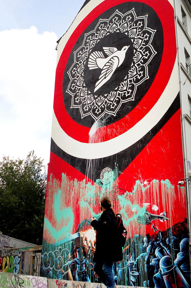 hærget. Nu er også Shepard Faireys nye udgave af vægmaleriet blevet oversprøjtet med maling. 