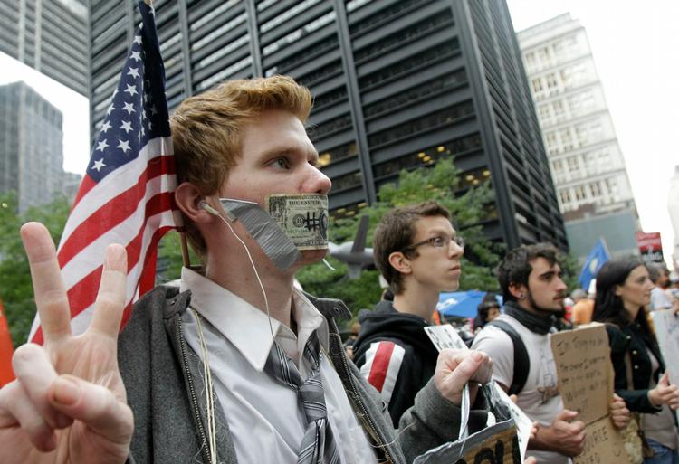 Protest. Igen i går var der protester mod finansverdenen i New York.  Robert James Carlson (tv.) havde sat en dollarseddel over munden. 