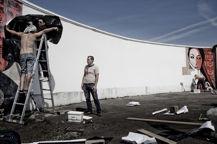 Vejrskifte. Der var høj sol, da Shepard Fairey (th.) besøgte Danmark i august og udsmykkede seks vægge. Siden har regn og rusk hærget værkerne. 