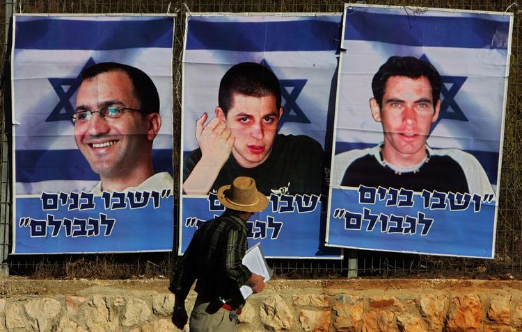 Fanget. En israeler passerer en plakat med tilfangetagne israelske soldater. Det er Gilad Shalit (i midten) som udløser næsten halvdelen af de 1.000 palæstinensere, som skal løslades i en fangeudveksling mellem Israel og Hamas. 