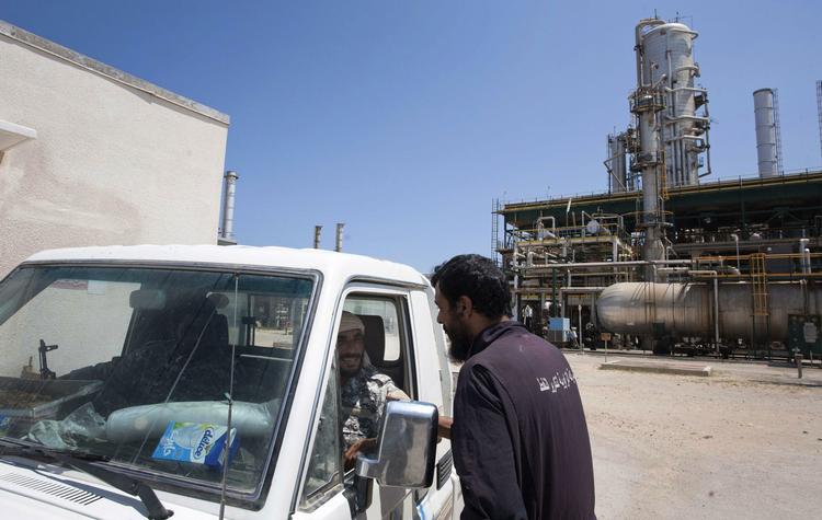 Nøgleproduktion. En libysk oliearbejder i snak med to oprørere, der afpatruljerer et oprørskontrolleret olieraffinaderi ved byen Zawiya. 