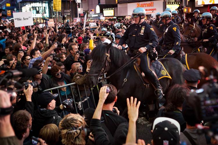 Massedemonstration. Beredne betjente forsøger at holde styr på mængden på New Yorks Times Square. 