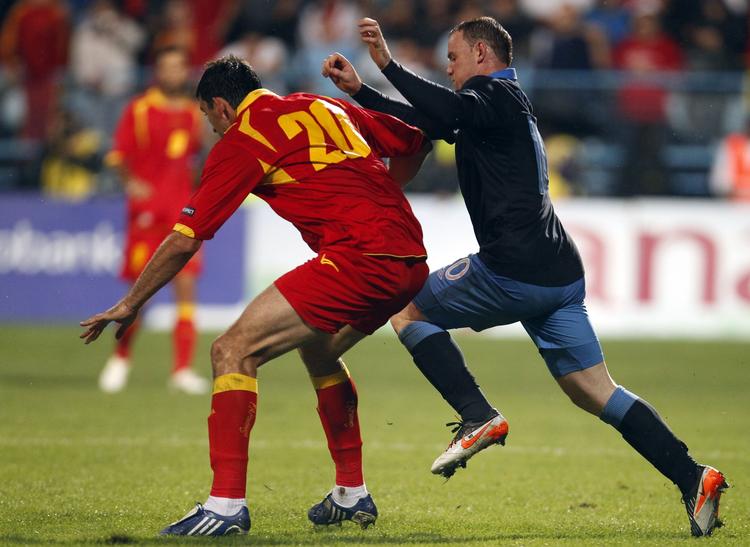 av. Miodrag Dzudovic (t.v.) har trods de blå mærker ondt af Wayne Rooney. 
