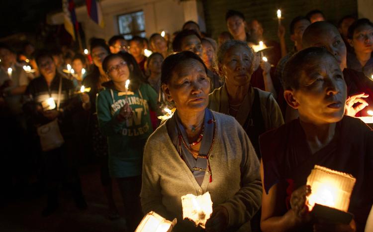 Respekt. Tibetanere, der er i eksil i Indien, tænder et lys for to munke, der satte ild til sig selv i september. 