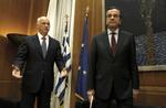 Den græske premierminister George Papandreou (tv) har sit at se til med en stor gæld på den ene side og en vred befolkning på den anden. Her står han sammen med den konservative oppositionsleder Antonis Samaras. 