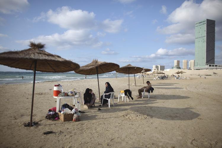 Strandliv. Indbyggere slapper af på stranden i Tripoli, Libyen. Landet har strande, der nemt kan hamle op med Tunesiens. 