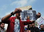 Oprør. En syrisk demonstrant brænder et billede af den mangeårige præsident, Bashar Al-Assad. 