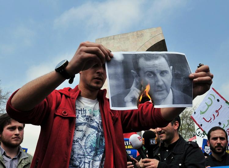 Oprør. En syrisk demonstrant brænder et billede af den mangeårige præsident, Bashar Al-Assad. 