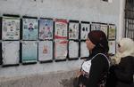 To tunesiske vælgere studerer valgplakater i hovedstaden Tunis. 
