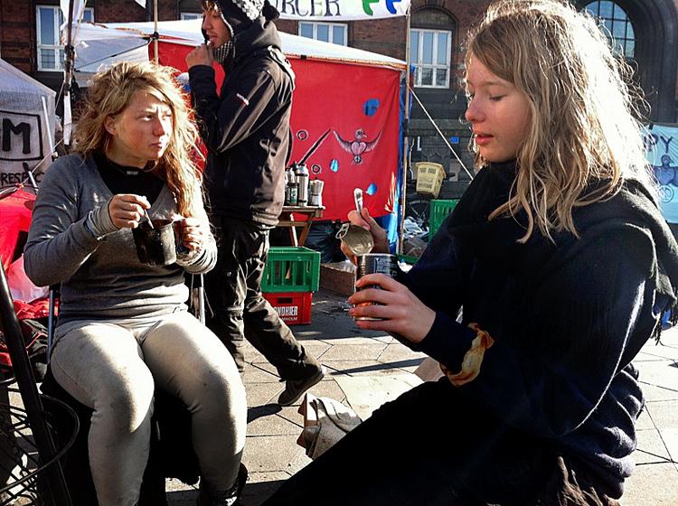 Dåsemad. Aktivister nyder kold mad fra dåse i solen. 