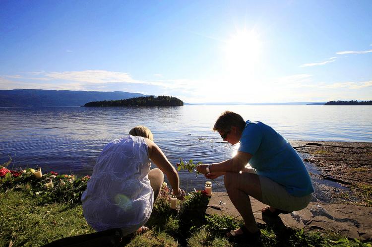 Tragedie. Et par lægger blomster til ære for ofrene for Utøya. Da det gik op for befolkningen, at gerningsmanden var en hvid gennemsnitsborger, gik Norge i chok. Foto:  Lefteris Pitarakis/AP 