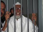 Forsvarstale. Abu Bakar Bashir fotograferet i en retssal i Jakarta i juni, hvor han taler til journalister gennem tremmerne i sit bur. 