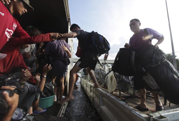 Væk. Thaier er på vej væk fra hovedstadens oversvømmede områder. 