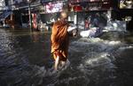 Oversvømmelse. En buddhistisk munk baner sig vej gennem vandmasserne i Bankok. 