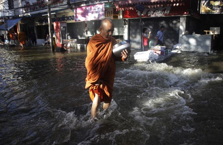 Oversvømmelse. En buddhistisk munk baner sig vej gennem vandmasserne i Bankok. 
