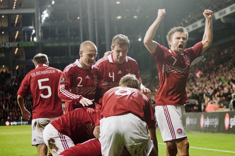 Jubel. Michael Krohn-Dehli ligger nederst i bunken efter at have bragt Danmark foran 1-0 mod Portugal. Willam Kvist brøler ud til publikum, mens Christian Eriksen (med nr. 8) og Niki Zimling (2) er på vej til at uddele krammere. 
