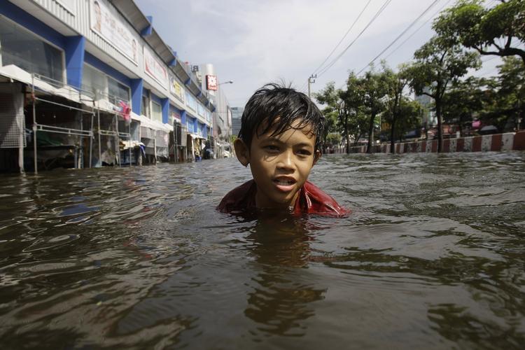 Oversvømmet. En dreng tager en søndagssvømmetur i en oversvømmet gade i Bangkok. 