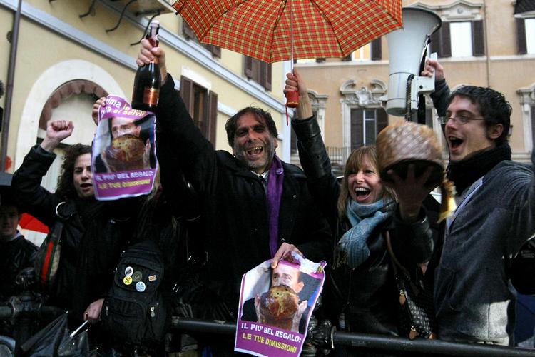Jubel. Demonstranter fejrer udmeldingen fra Silvio Berlusconi: 'Din mest vidunderlige gave: Din afsked'. 