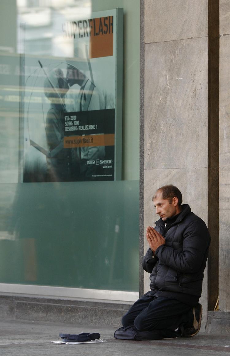 Krise. Milano i går. En mand beder om en skærv foran en af byens banker. 
