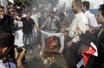 Protest. Syriske oprørere brænder et billede af præsident Assad af foran Den Arabiske Ligas hovedkvarter i Kairo, Egypten. 