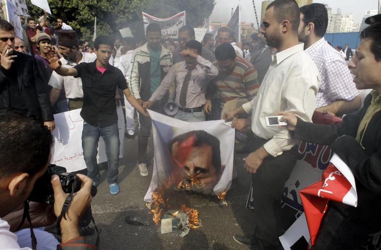 Protest. Syriske oprørere brænder et billede af præsident Assad af foran Den Arabiske Ligas hovedkvarter i Kairo, Egypten. 