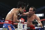 Bang. Den forsvarende mester Manny Pacquiao (t.v.) rammes hårdt af Juan Manuel Marquez. 