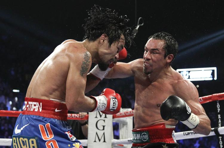 Bang. Den forsvarende mester Manny Pacquiao (t.v.) rammes hårdt af Juan Manuel Marquez. 
