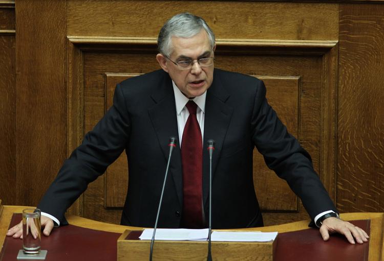 Hårdt. Lucas Papademos havde den alvorlige mine på i parlamentet i Athen til aften. Der er svære tider på vej. 