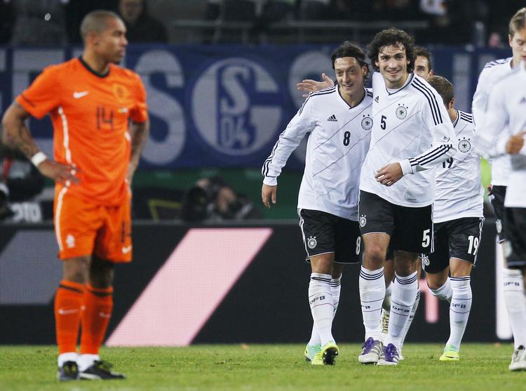 Målscorer. Mesut Oezil (i midten) blev kampens sidste målscorer og får lykønskninger fra holdkammerat Mats Hummels, mens hollandske Nigel de Jong sukker. 
