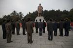 På en plads foran universitetet i Pyongyang har en gruppe mænd stillet sig op for at vise deres respekt for Kim Il-sung, der var Nord-Koreas leder til 1994 - og far til afdøde Kim Jong-il. 