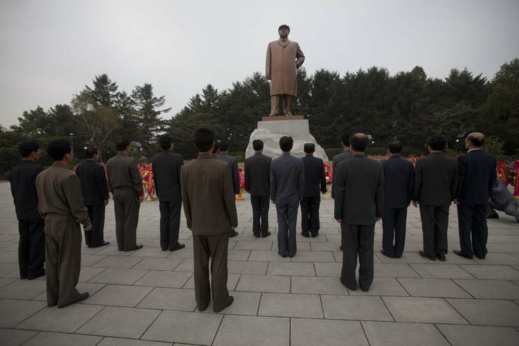 På en plads foran universitetet i Pyongyang har en gruppe mænd stillet sig op for at vise deres respekt for Kim Il-sung, der var Nord-Koreas leder til 1994 - og far til afdøde Kim Jong-il. 