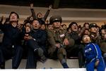 Nord-Koreanske fodboldfans hepper på deres landshold under en kamp mod Uzbekistan på Yanggakdo Stadium i Pyongyang. 
