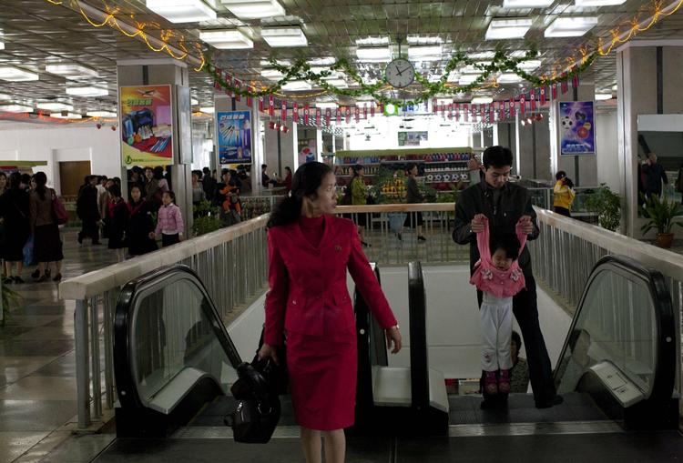 En mand løfter sit barn efter at have taget turen op med rulletrapperne i det såkaldte  Pyongyang Stormagasin nr. 1, der ligger midt i byen. 