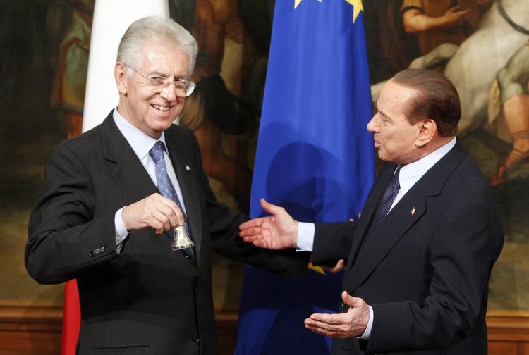 Gave. Italiens nye ministerpræsident  Mario Monti (tv.) fik - at han var blevet taget i ed - en lille klokke af den tidligere regeringschef Silvio Berlusconi. 