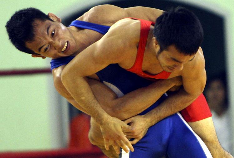 olympisk. Vietnams Dong Van Bien (tv) kæmper hårdt for at få tag i filippineren Angana Margarito i 55 kiloklassen i græsk-romersk brydning ved mesterskaberne i Indonesien. 