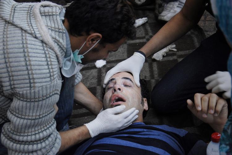 Uroen i Kairo har stået på siden fredag og er tiltaget i styrke, især da politi og militær forsøgte at rydde pladsen sent søndag. Her hjælpes en såret demonstrant på Tahrir-pladsen. 